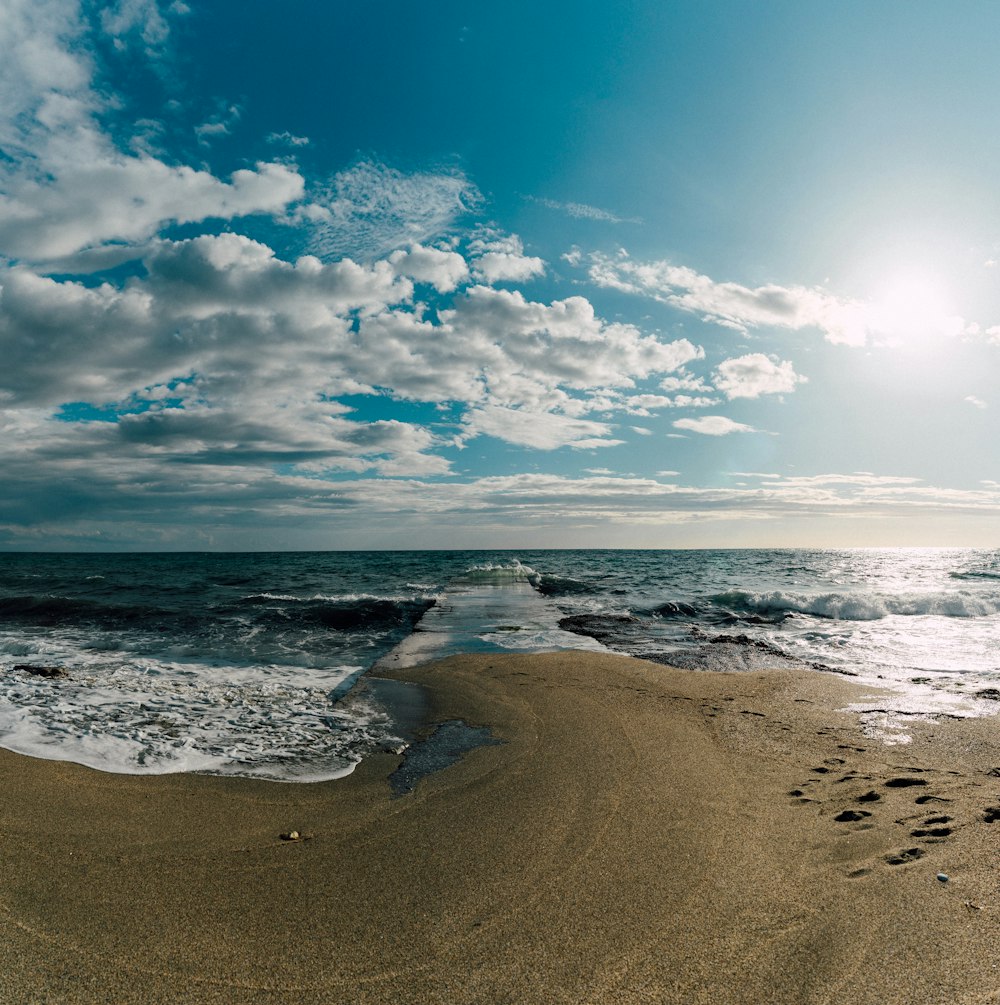 a sandy beach with footprints in the sand