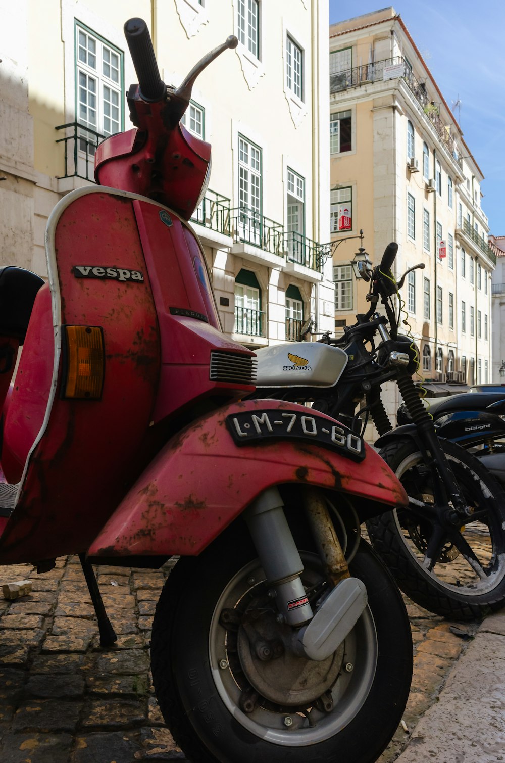 a red scooter parked on the side of a street