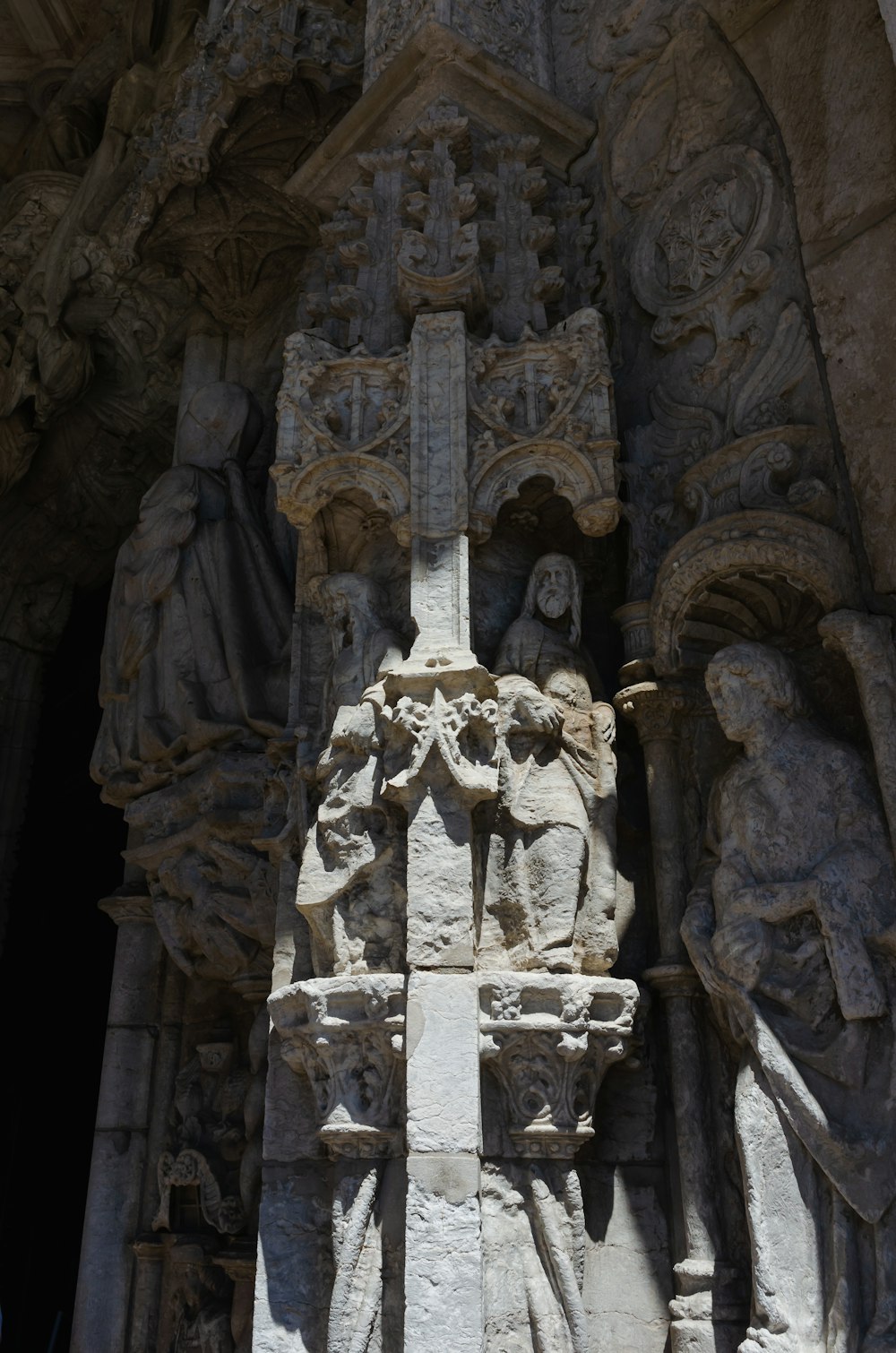 a statue of a cross on the side of a building