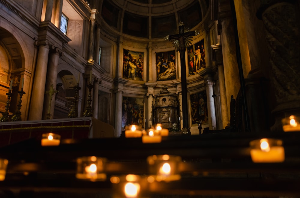 candles are lit in front of a church alter