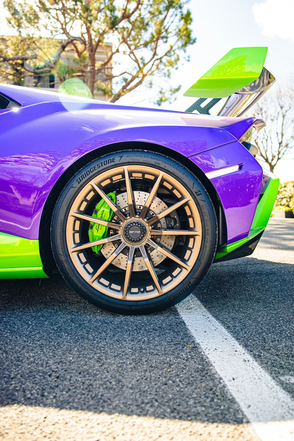 a purple and green sports car parked in a parking lot