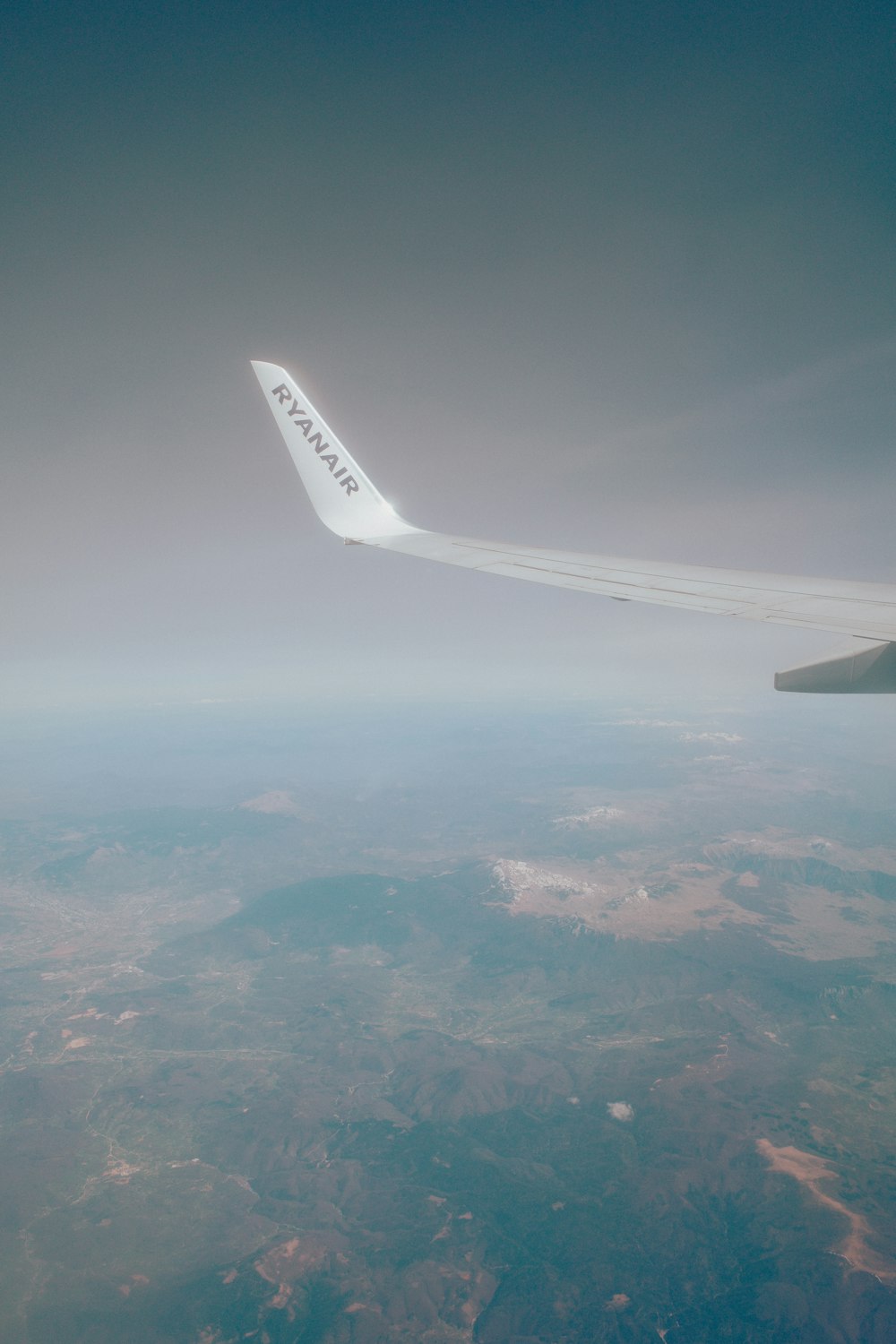 the wing of an airplane flying in the sky