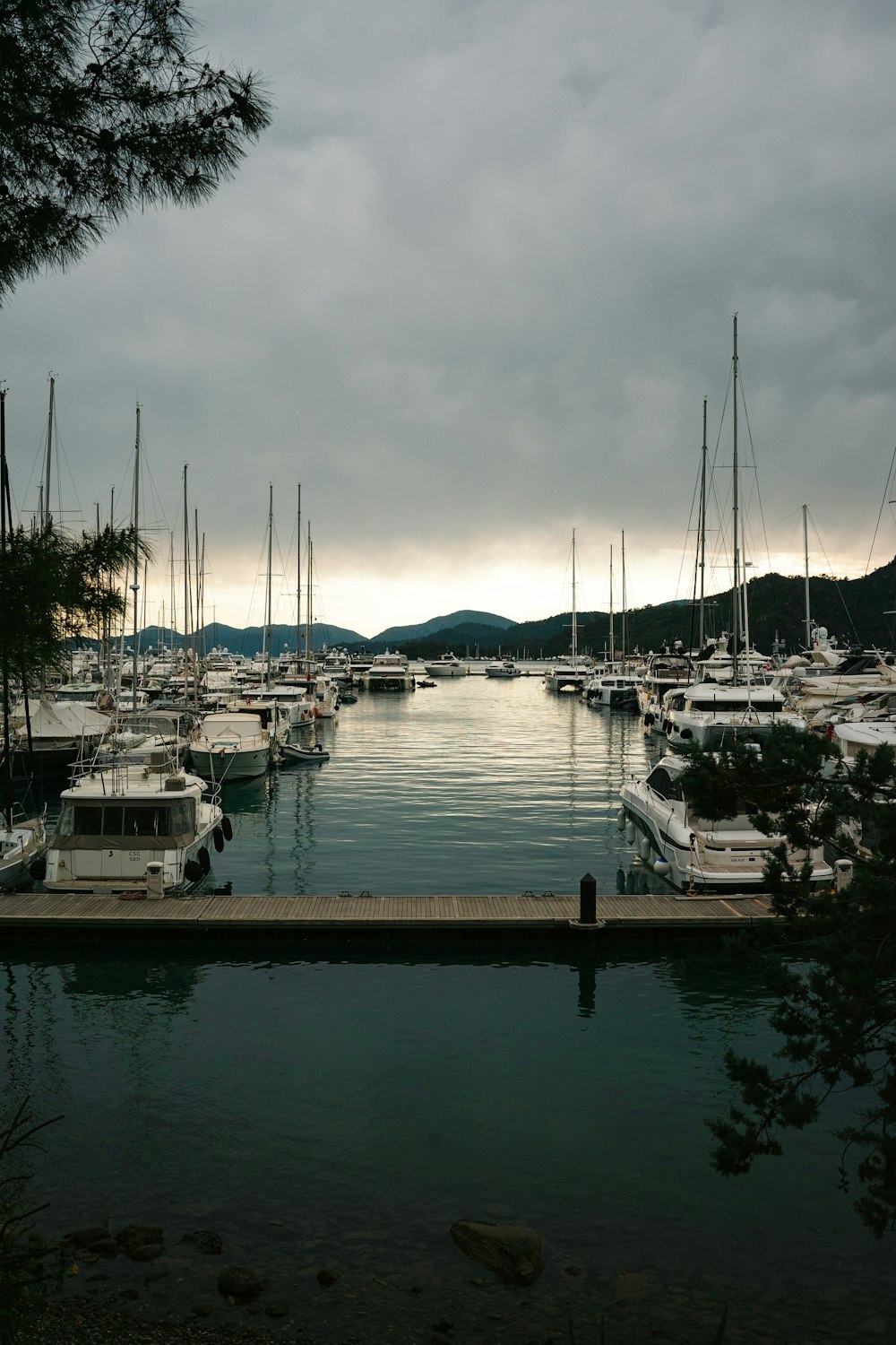 a harbor filled with lots of boats under a cloudy sky