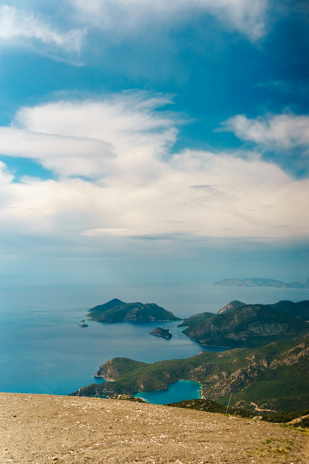 a bench sitting on top of a hill overlooking a body of water