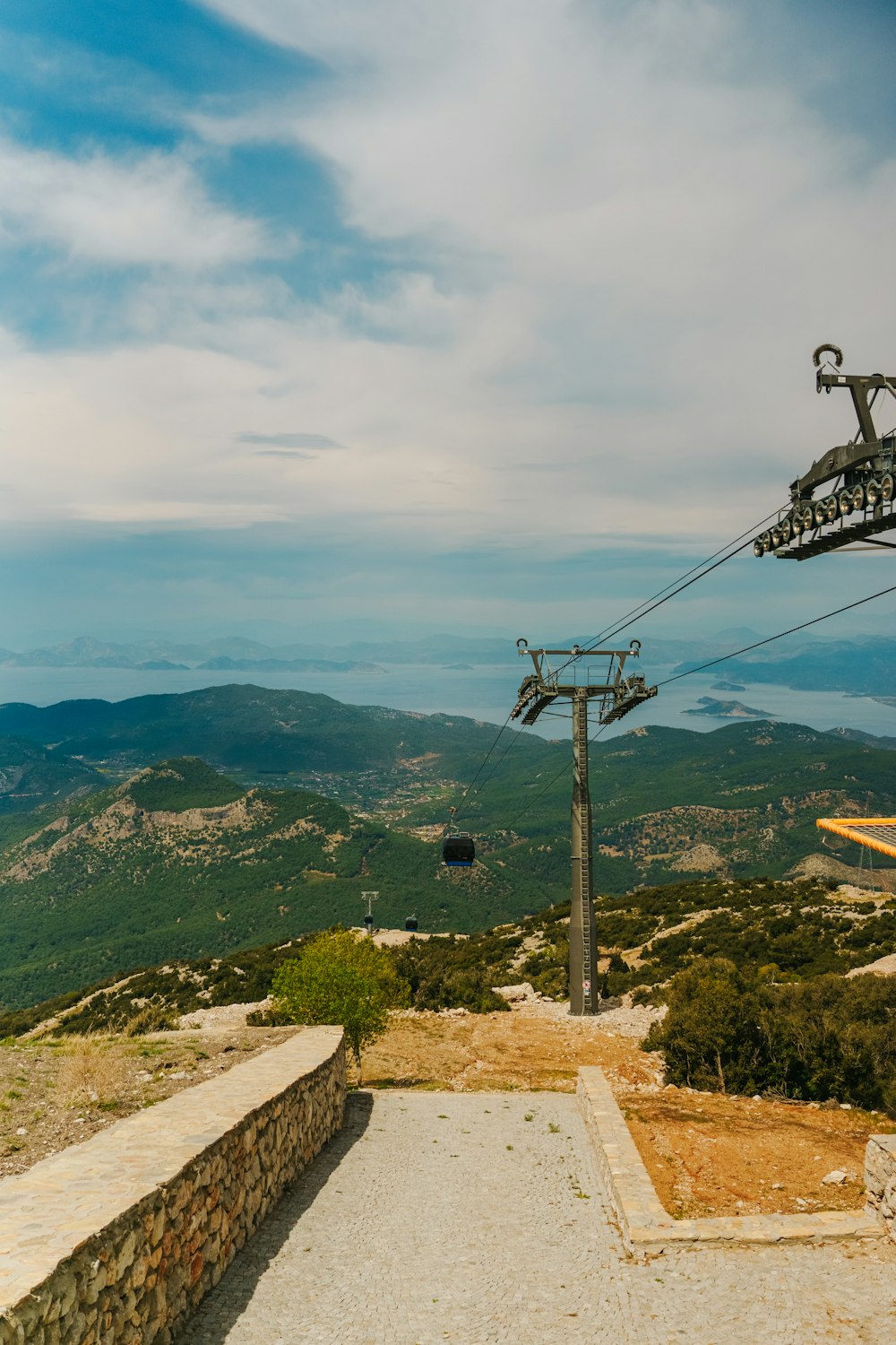 a ski lift going up a hill with mountains in the background