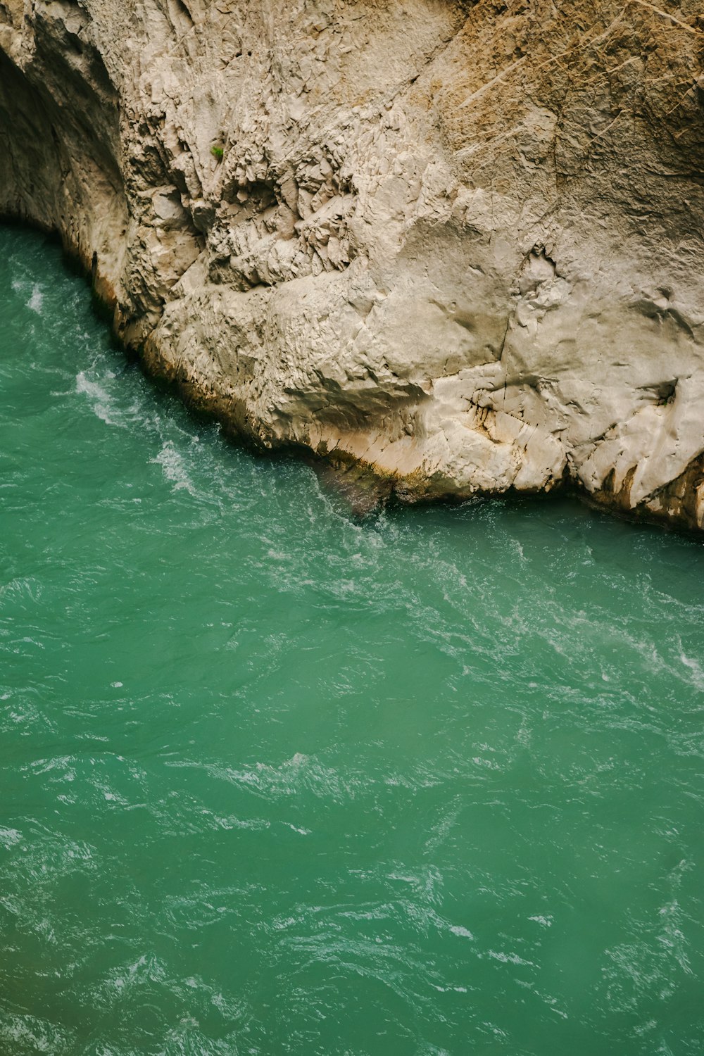 a man in a kayak in the water next to a cliff