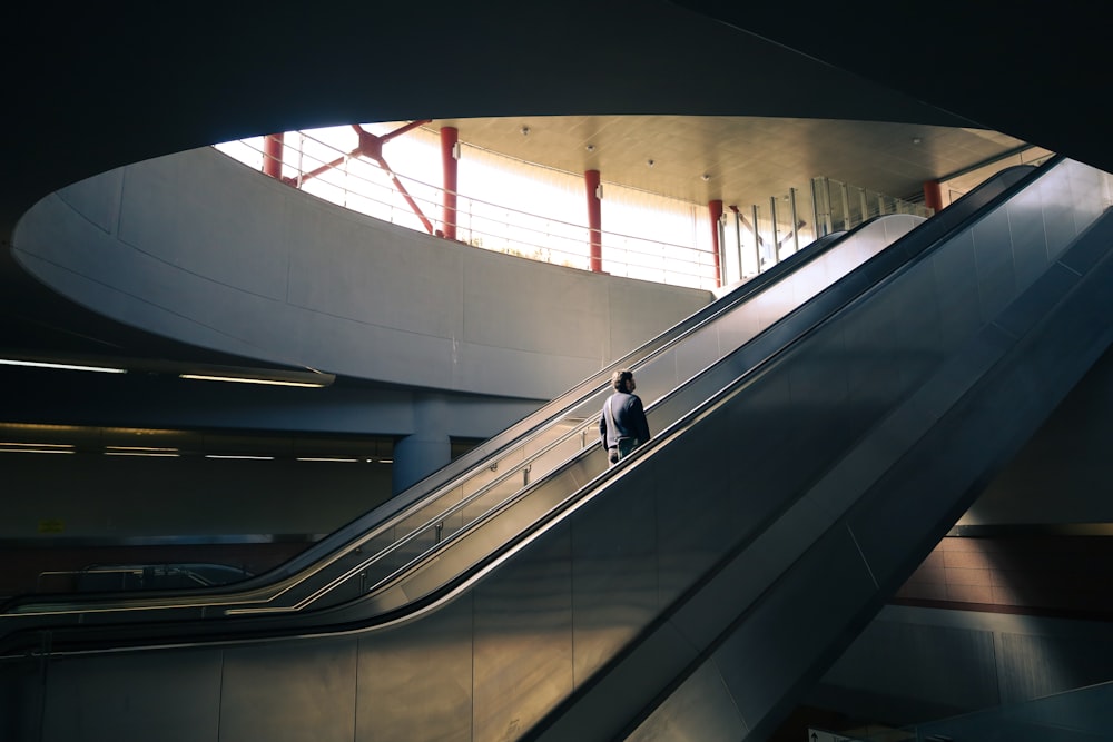 ein Mann, der auf einer Rolltreppe in einem Gebäude steht