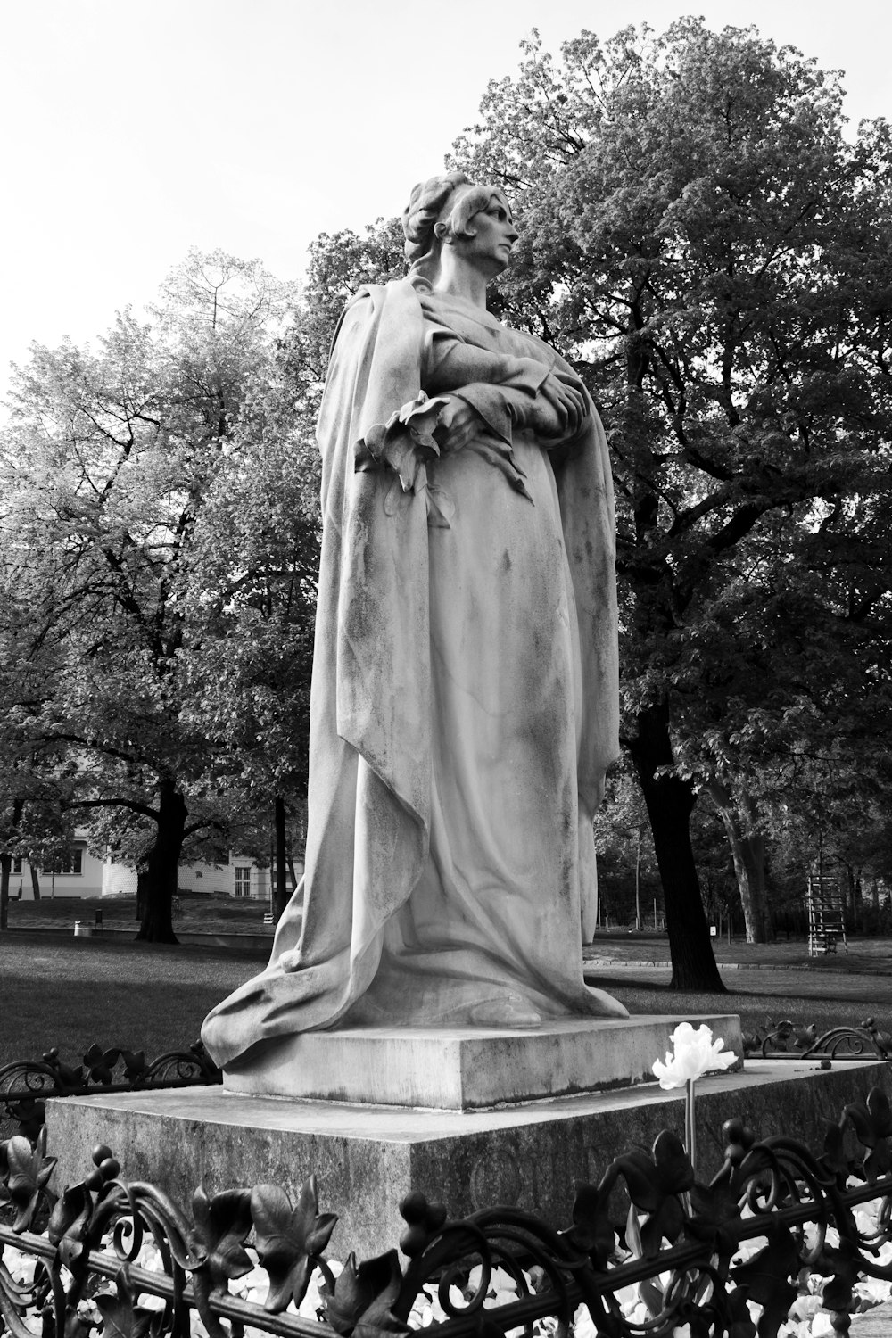a black and white photo of a statue in a park