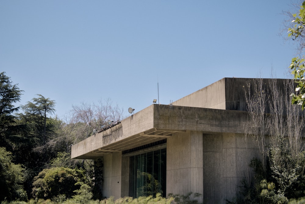 a concrete building with trees in the background