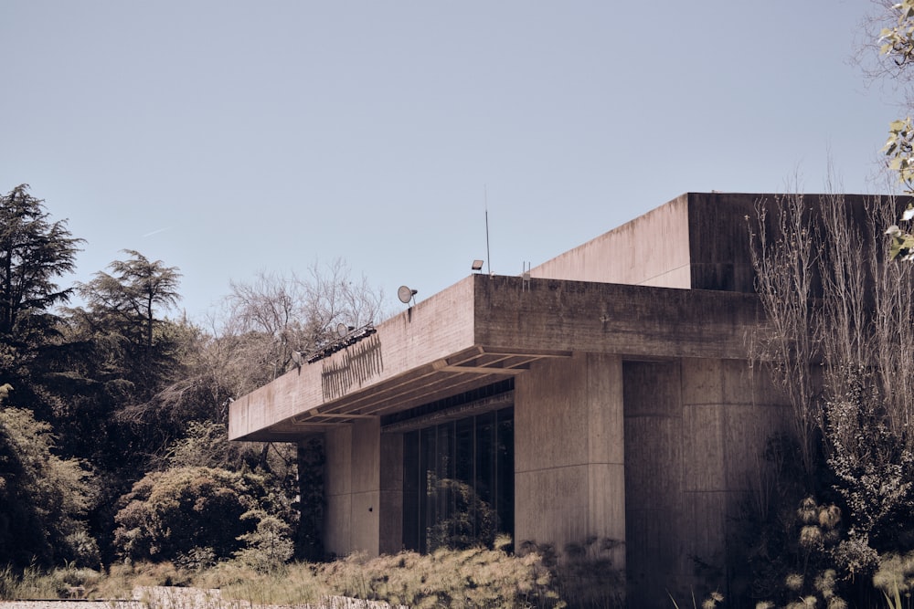 a concrete building with trees in the background