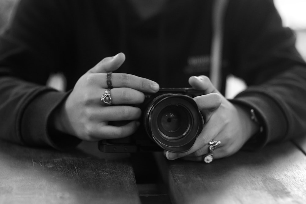 a black and white photo of a person holding a camera