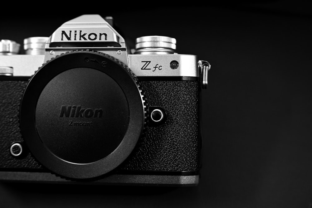 a black and white photo of a nikon camera