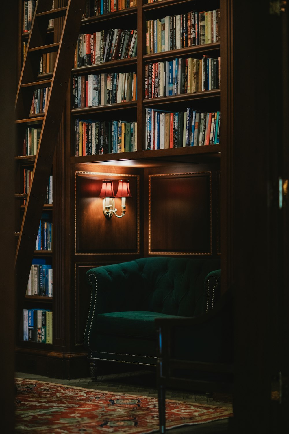 a green couch sitting in front of a bookshelf filled with books