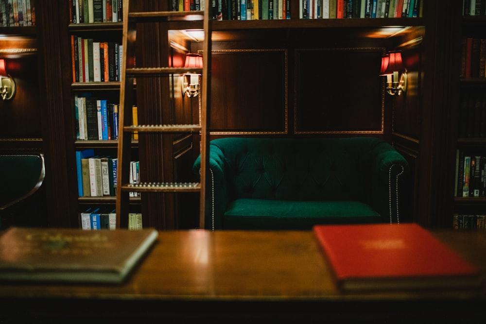 a green chair sitting in front of a bookshelf filled with books