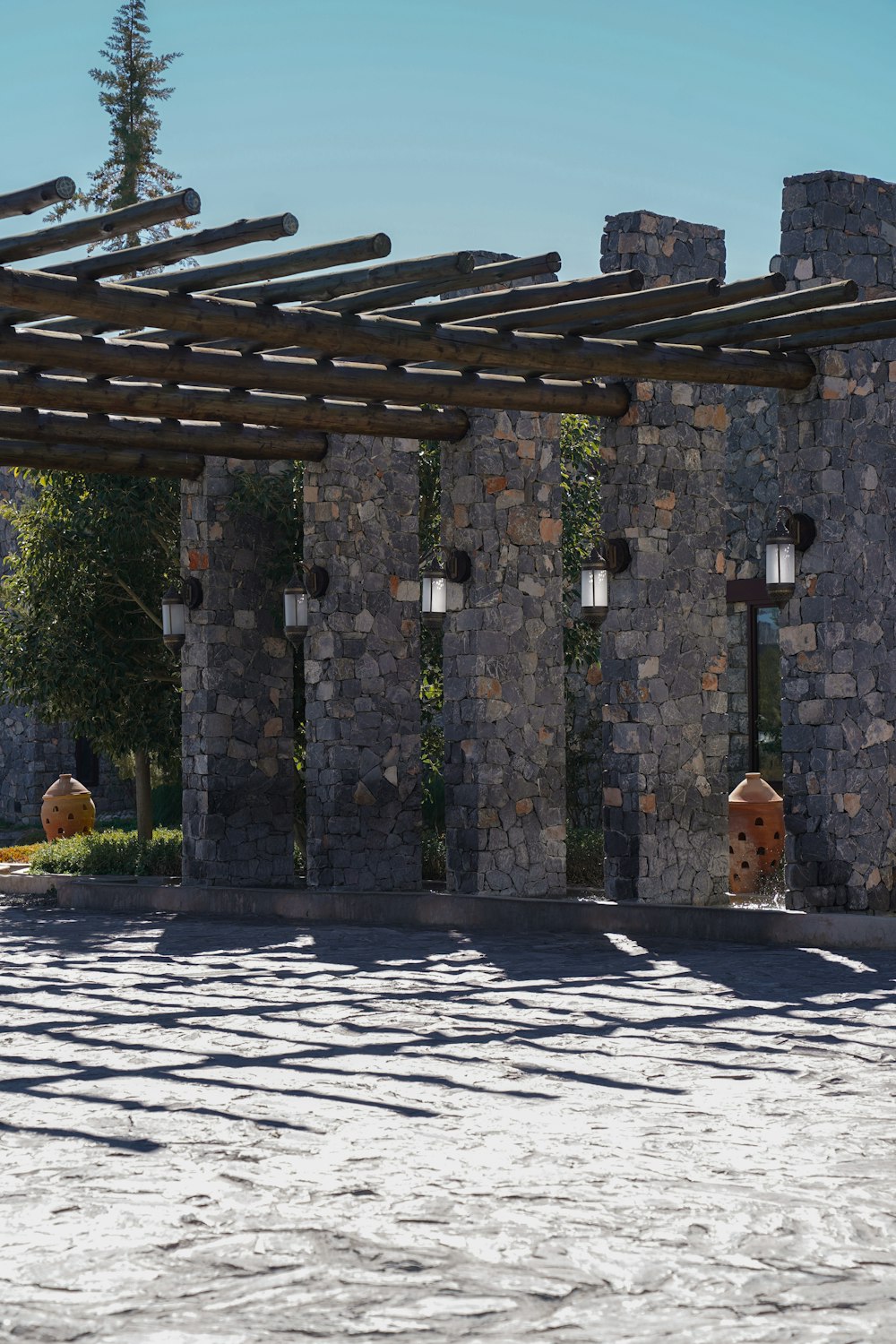 a stone building with a pergolated roof