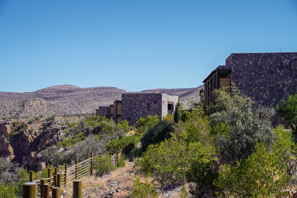 a building in the middle of a desert with mountains in the background