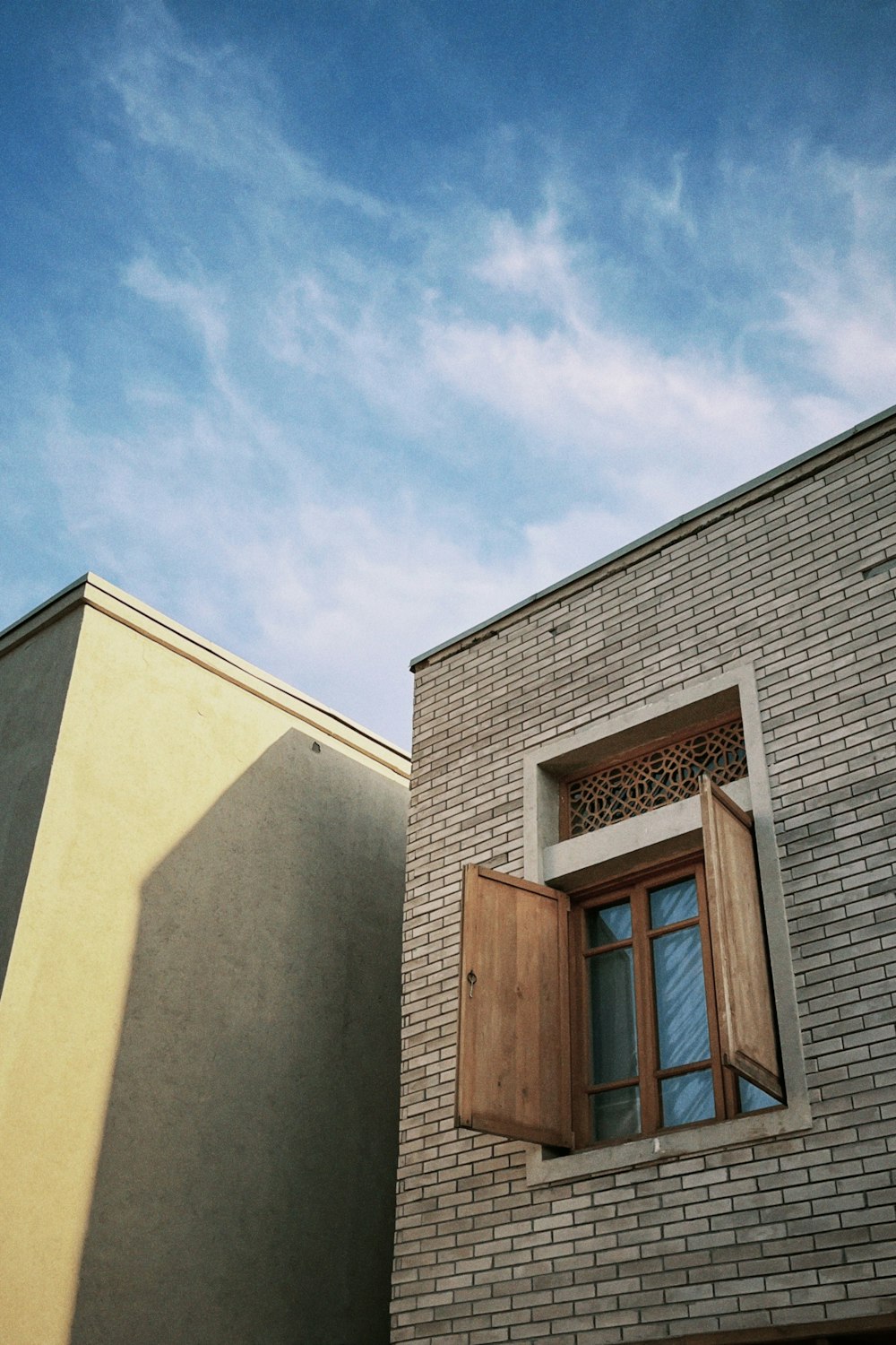 a brick building with a window and shutters