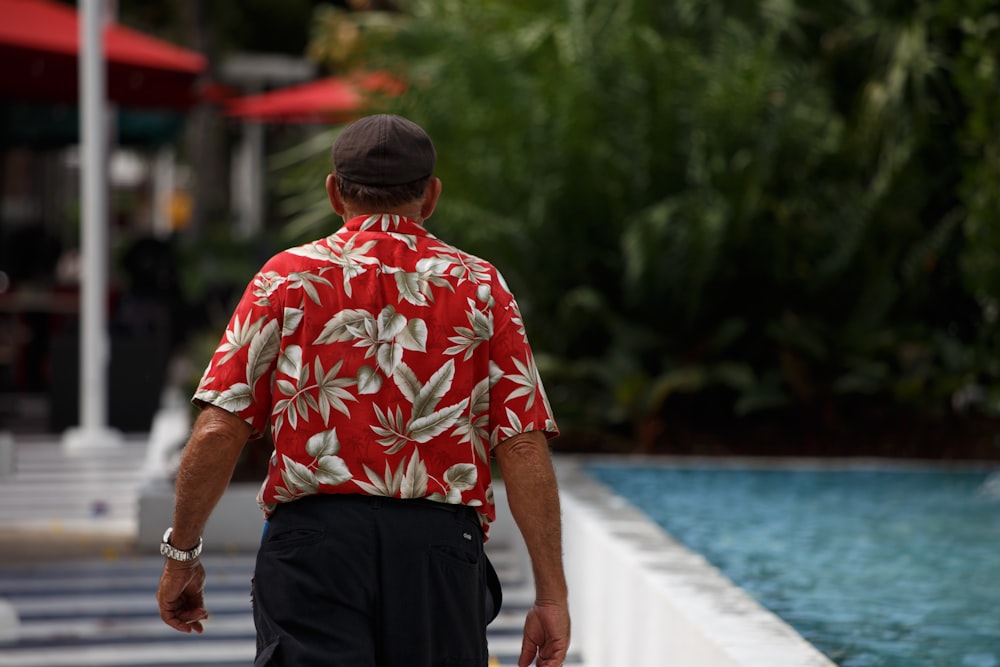 a man in a red shirt walking down a street