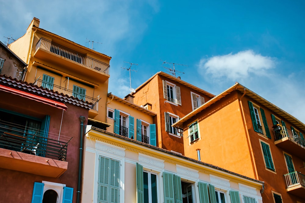 a row of multi - colored buildings with balconies and shutters