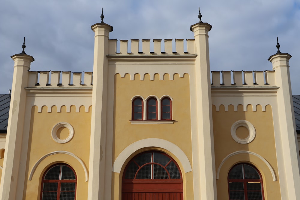 a large yellow building with a red door