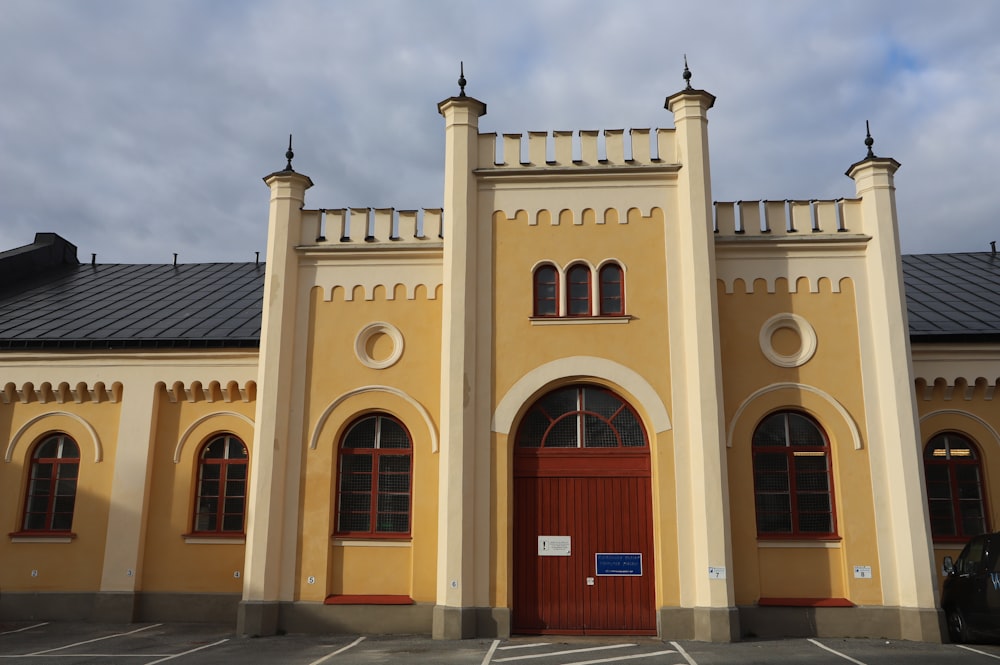 a large yellow building with a red door