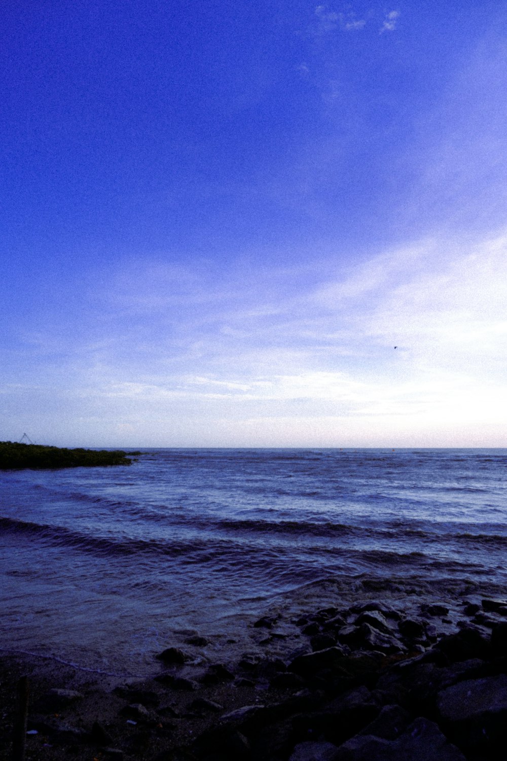 a view of a body of water from a rocky shore
