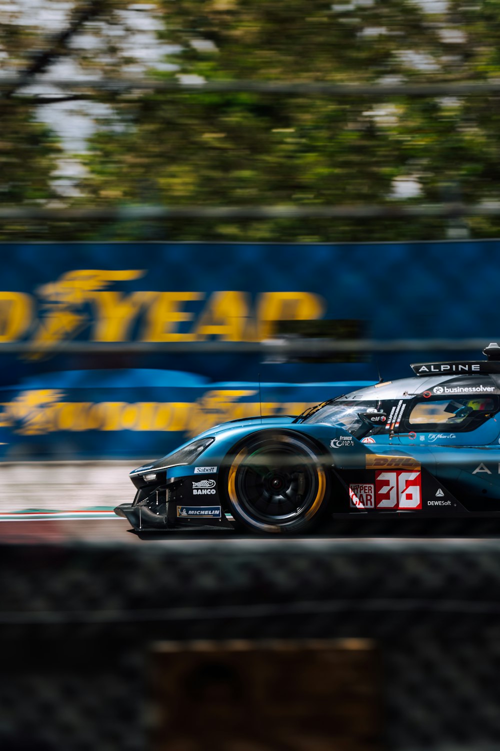 a blue race car driving down a race track