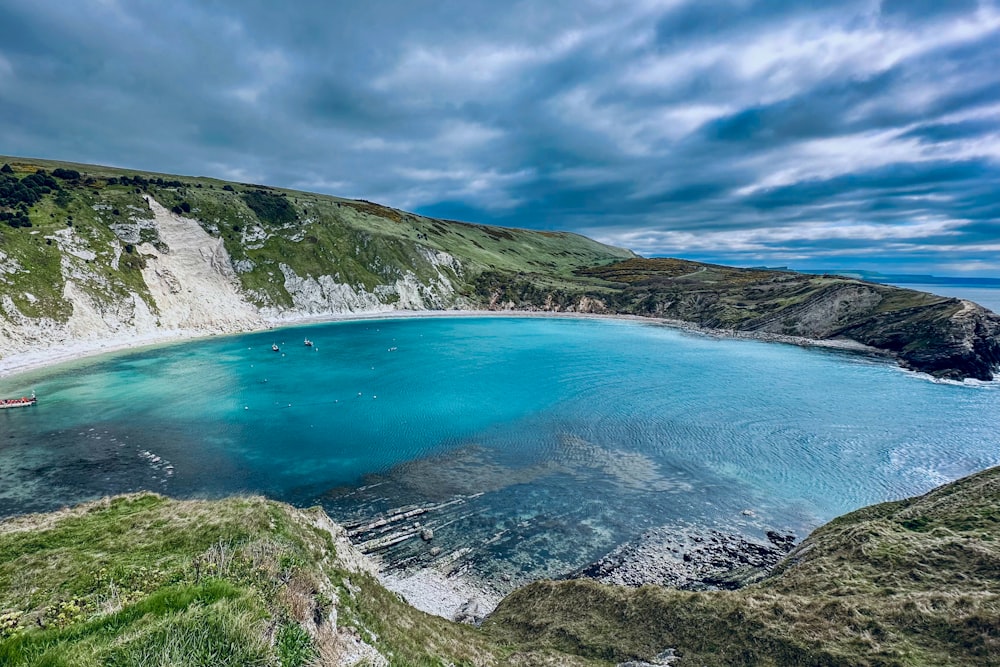 Un cuerpo de agua azul rodeado de verdes colinas