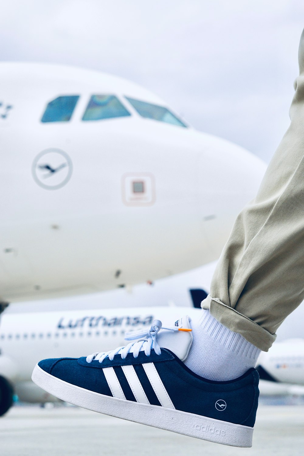 a person's feet in a pair of blue adidas sneakers