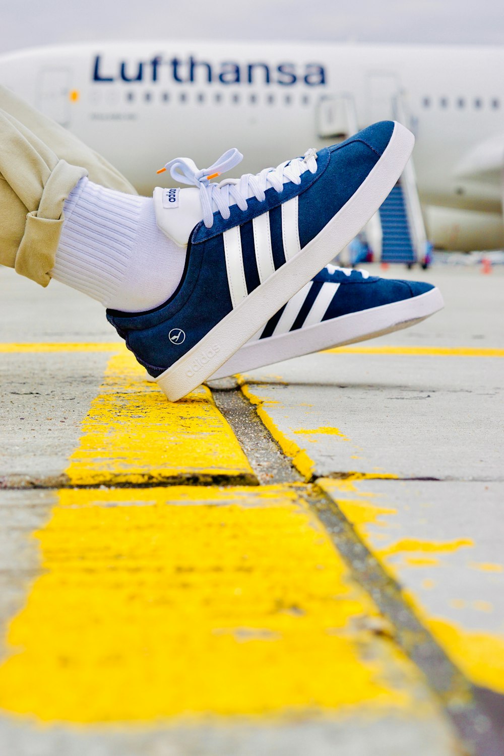 a person's feet on the ground with a plane in the background