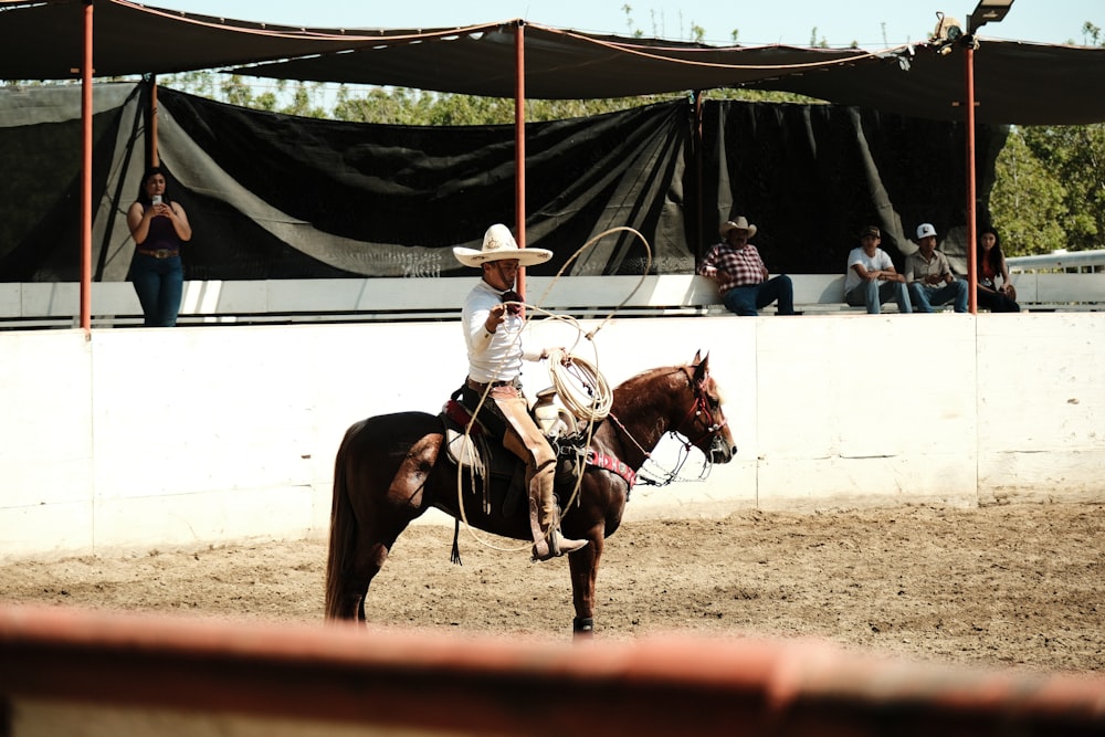 a man riding on the back of a brown horse