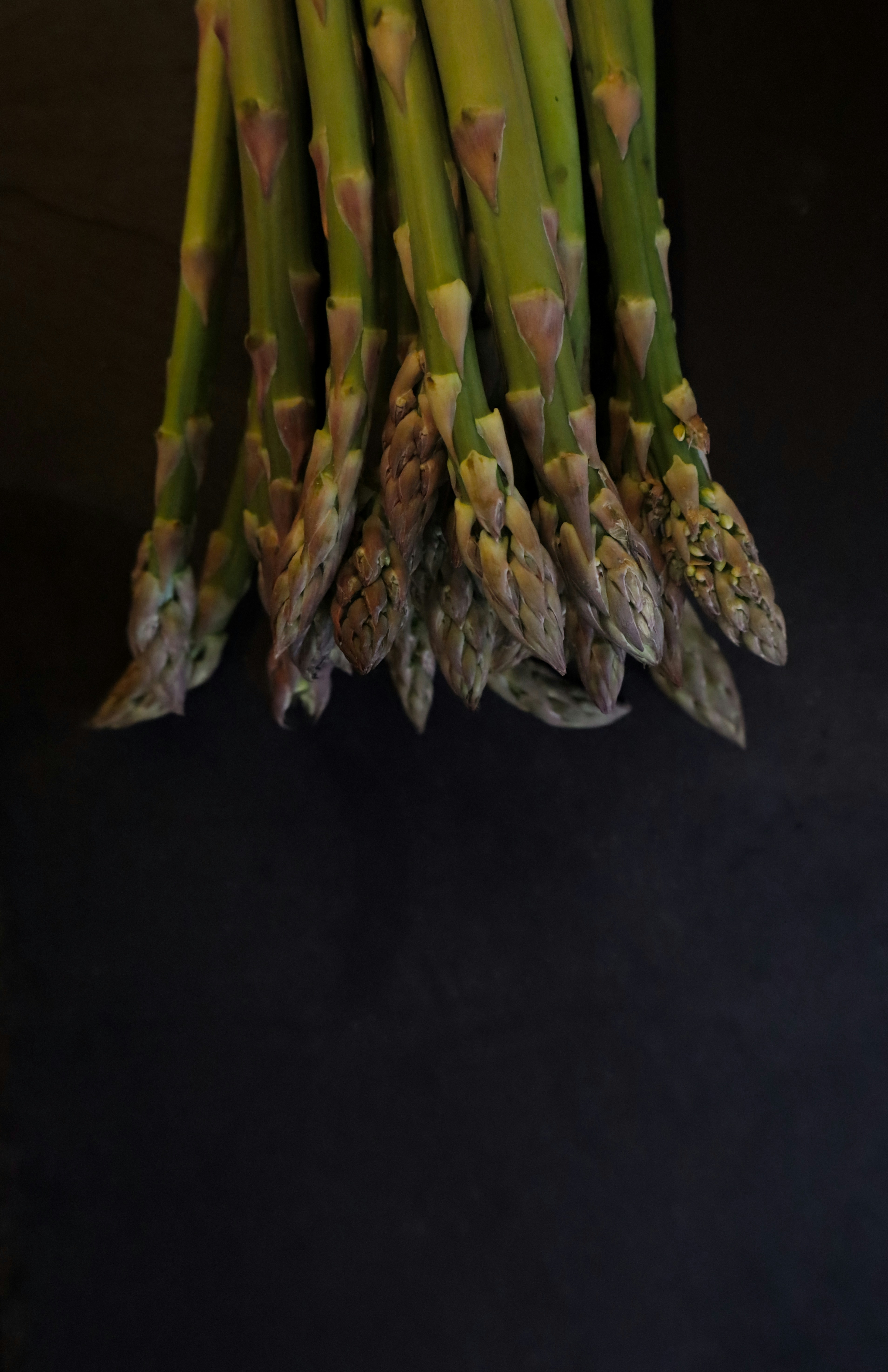 a bunch of asparagus on a black background