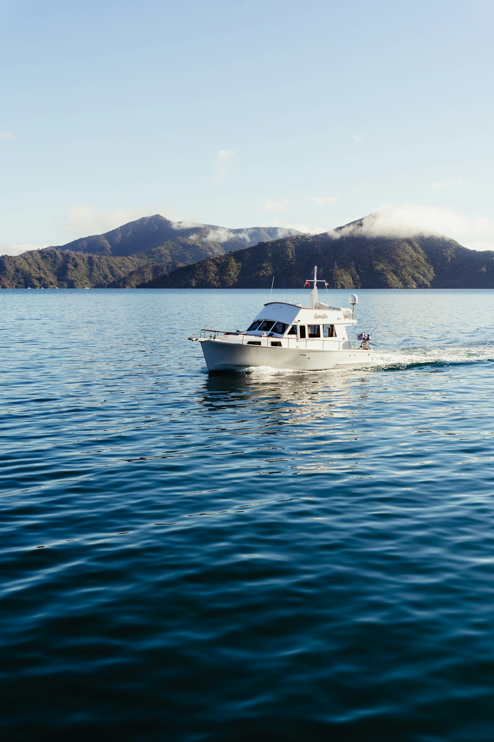 a white boat traveling across a large body of water