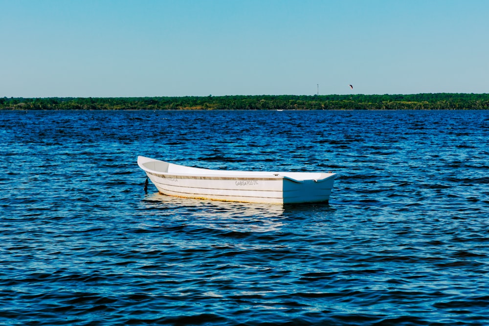 a white boat floating on top of a large body of water