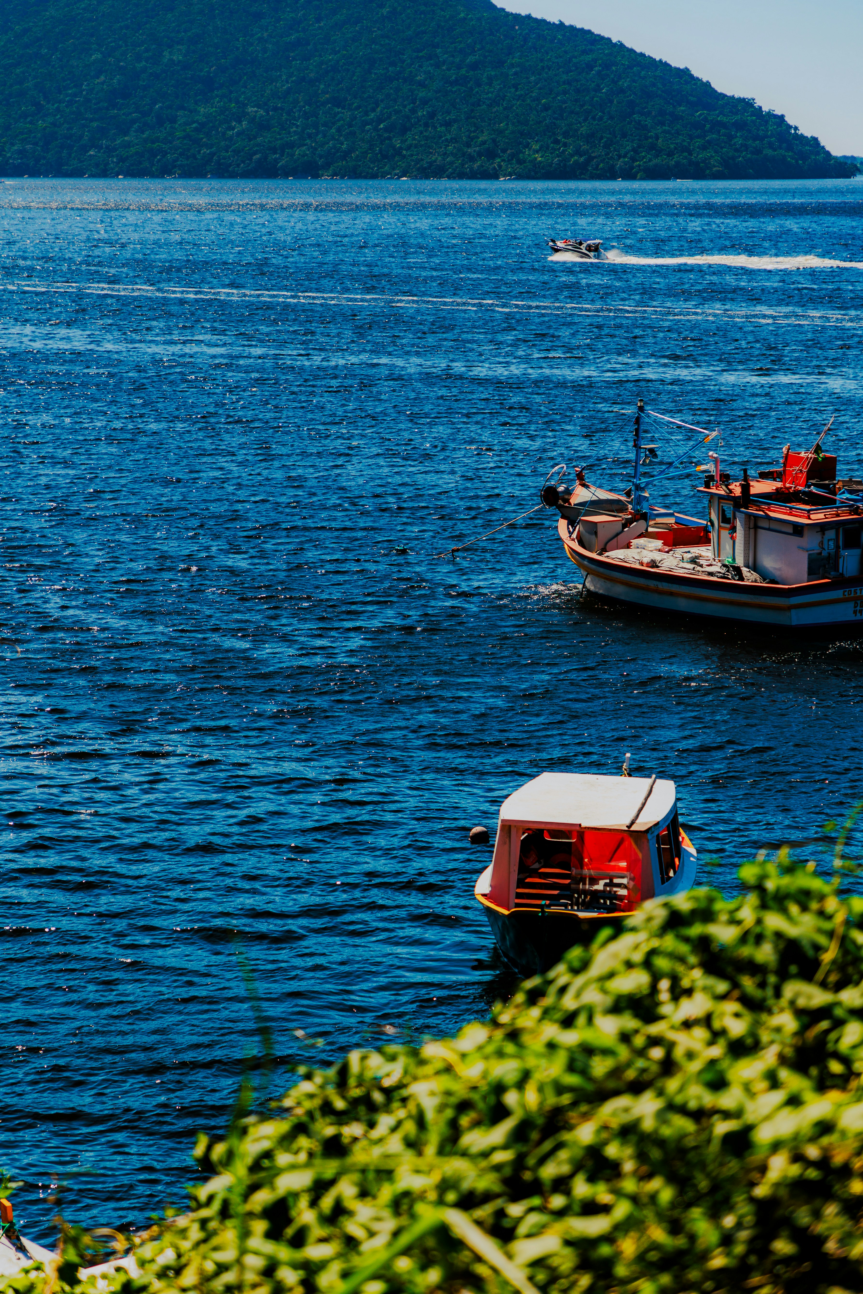 a couple of boats floating on top of a large body of water