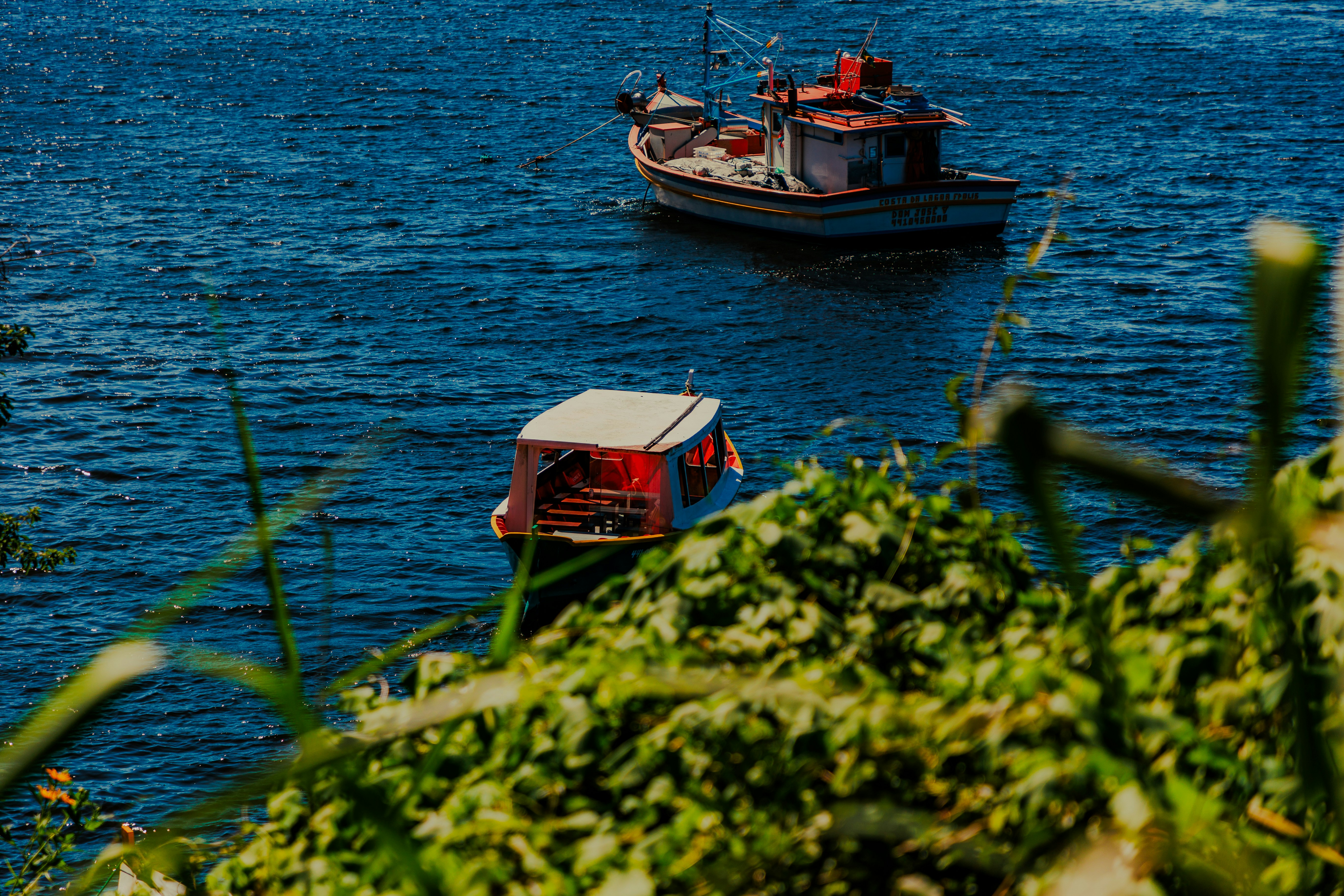 a couple of boats floating on top of a body of water