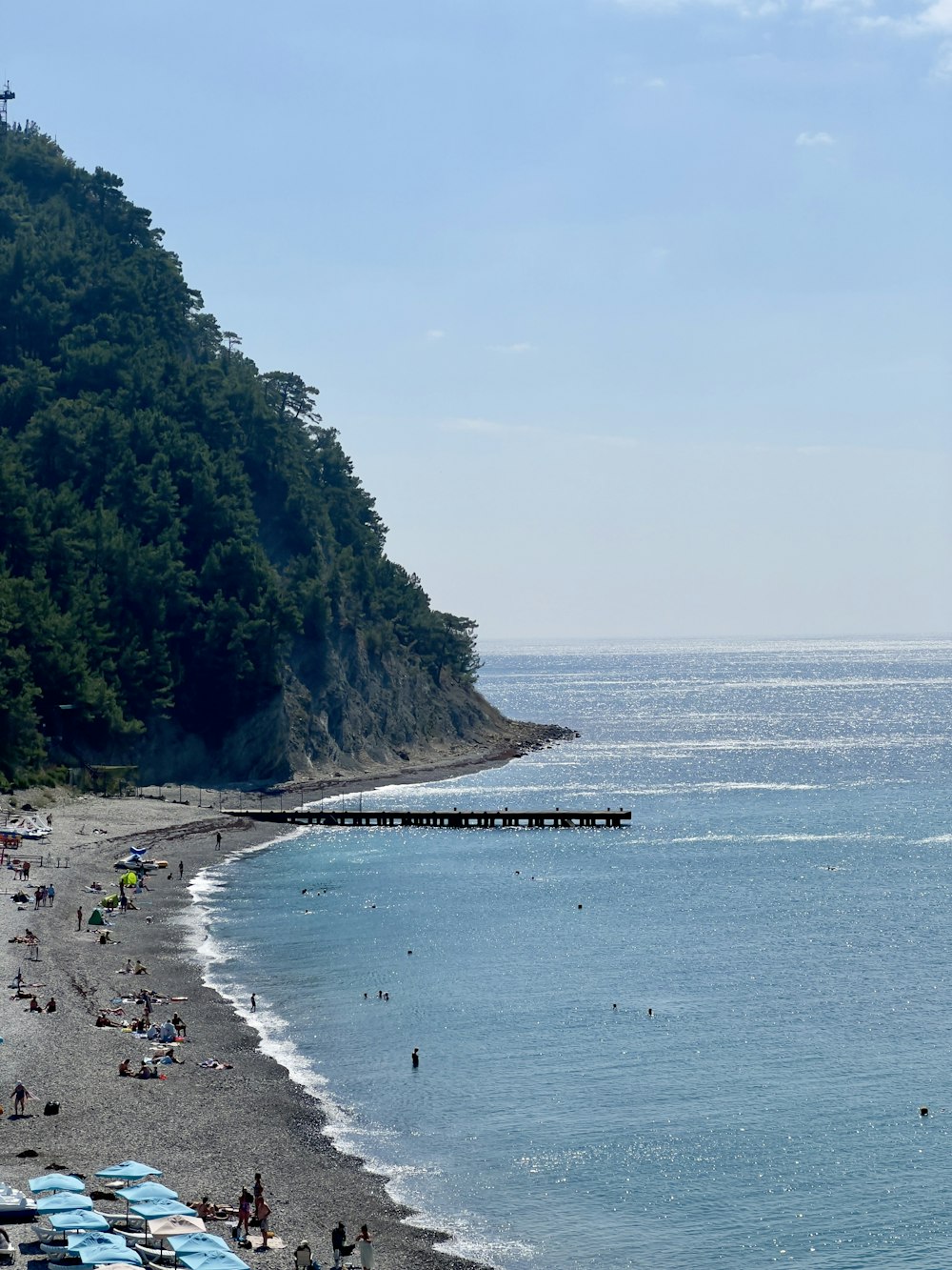 a group of people standing on top of a beach next to the ocean