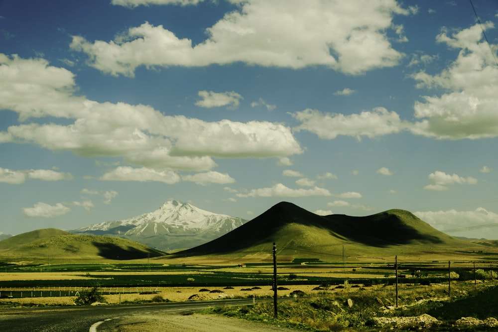 a dirt road with a mountain in the background