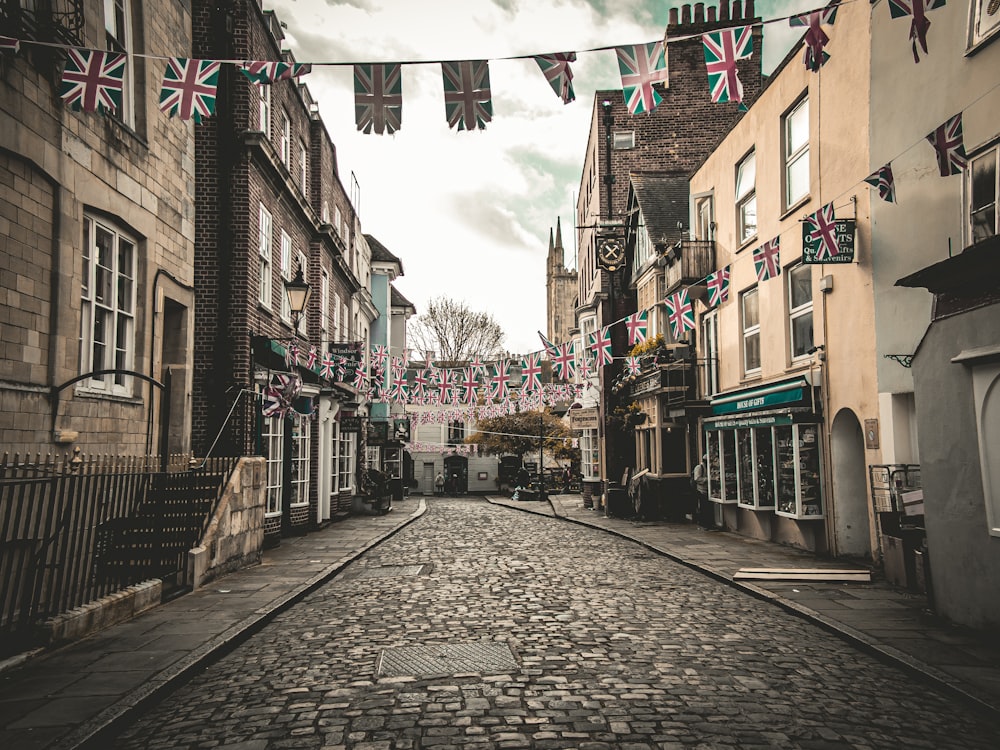 a cobblestone street lined with buildings and bunting