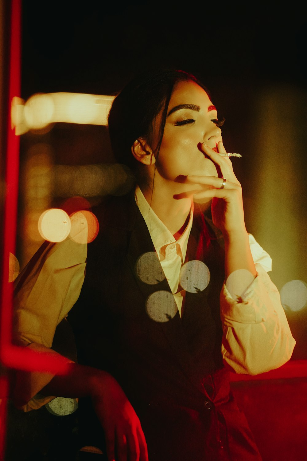 a woman smoking a cigarette while sitting down