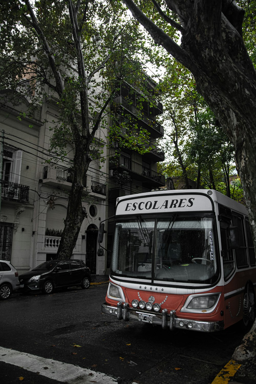 a red and white bus parked on the side of the road