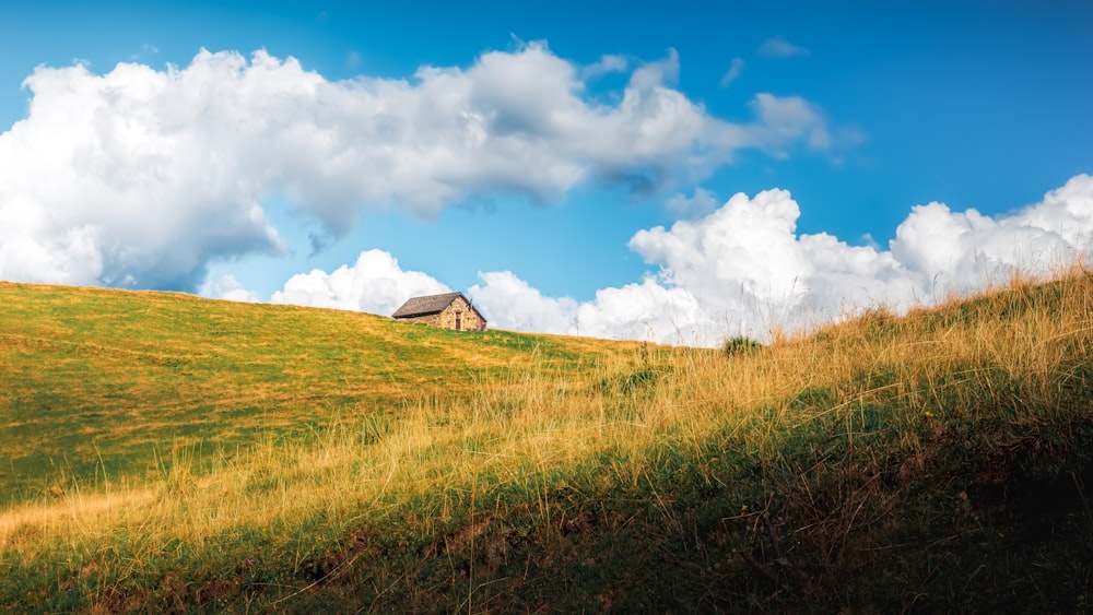 a grassy hill with a house on top of it