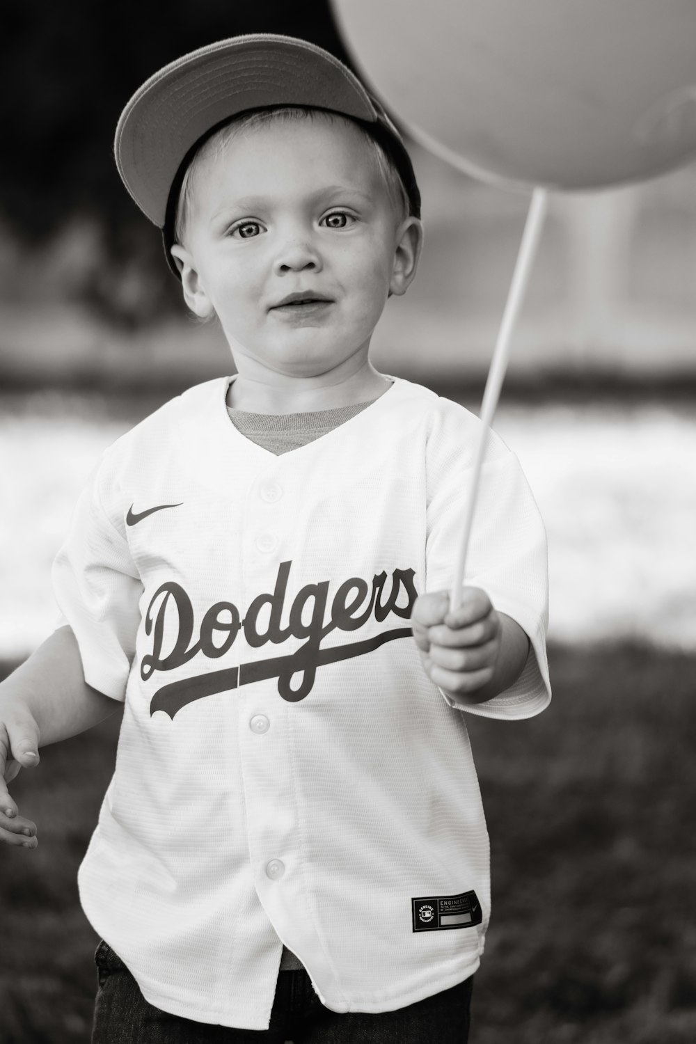 Un niño con un uniforme de béisbol sosteniendo un globo