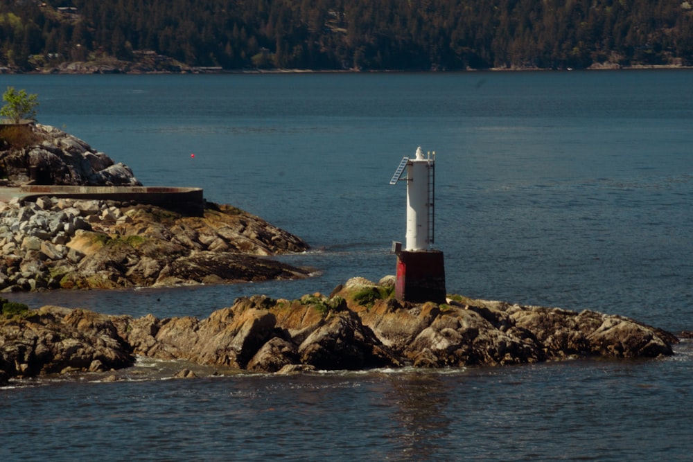 a lighthouse on a small island in the middle of a lake