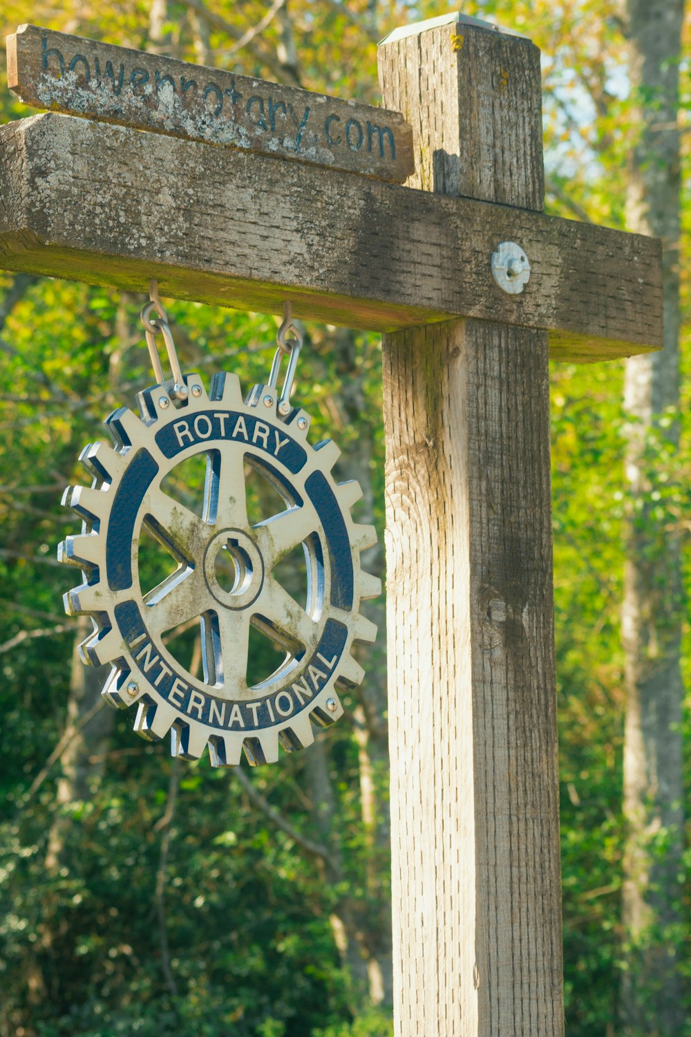 a close up of a wooden sign with a clock on it