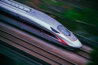 a silver and red train traveling down train tracks