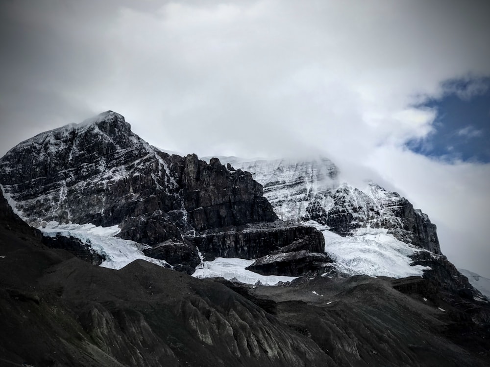 a snow covered mountain with clouds in the sky