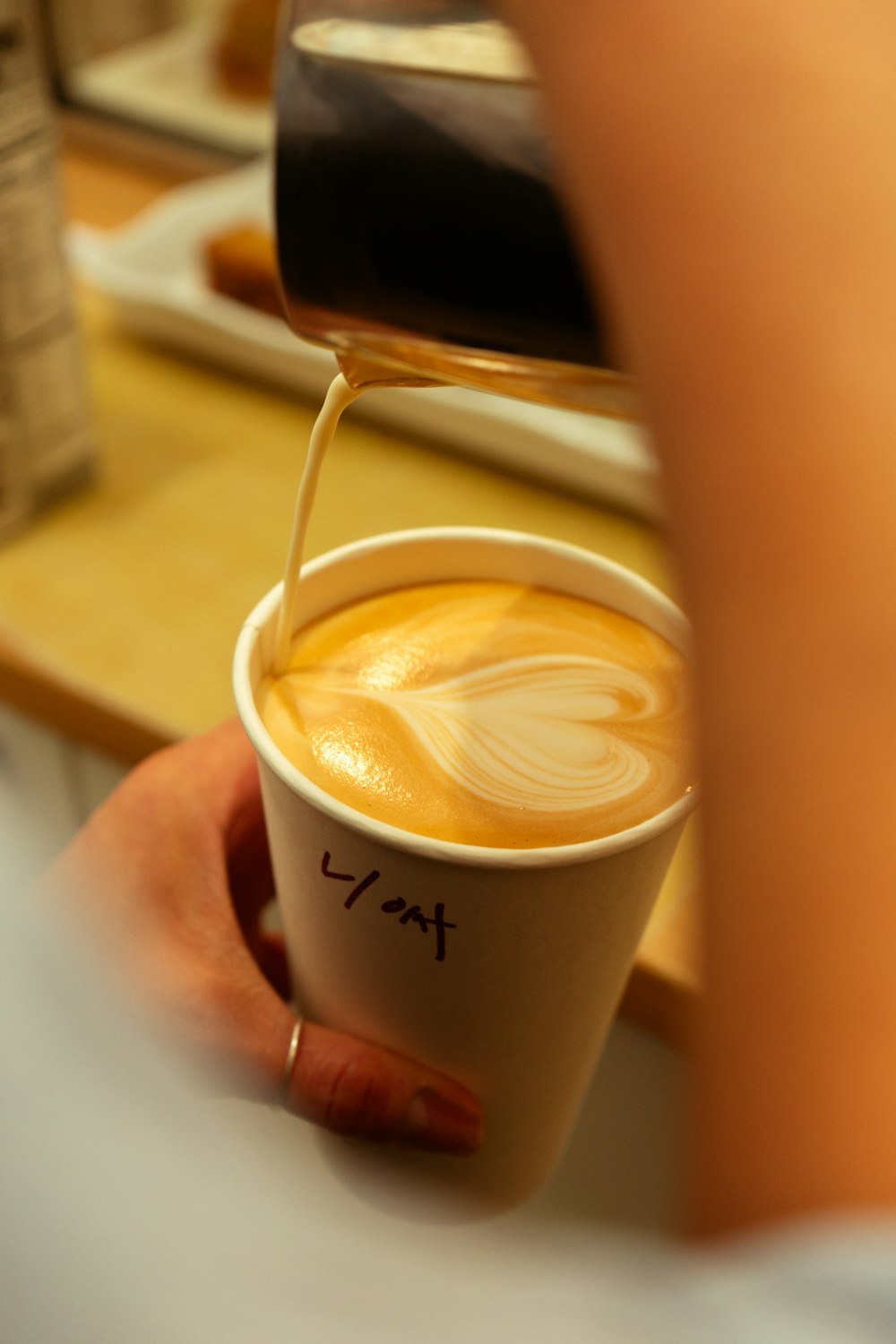 a cup of coffee being poured into a cup