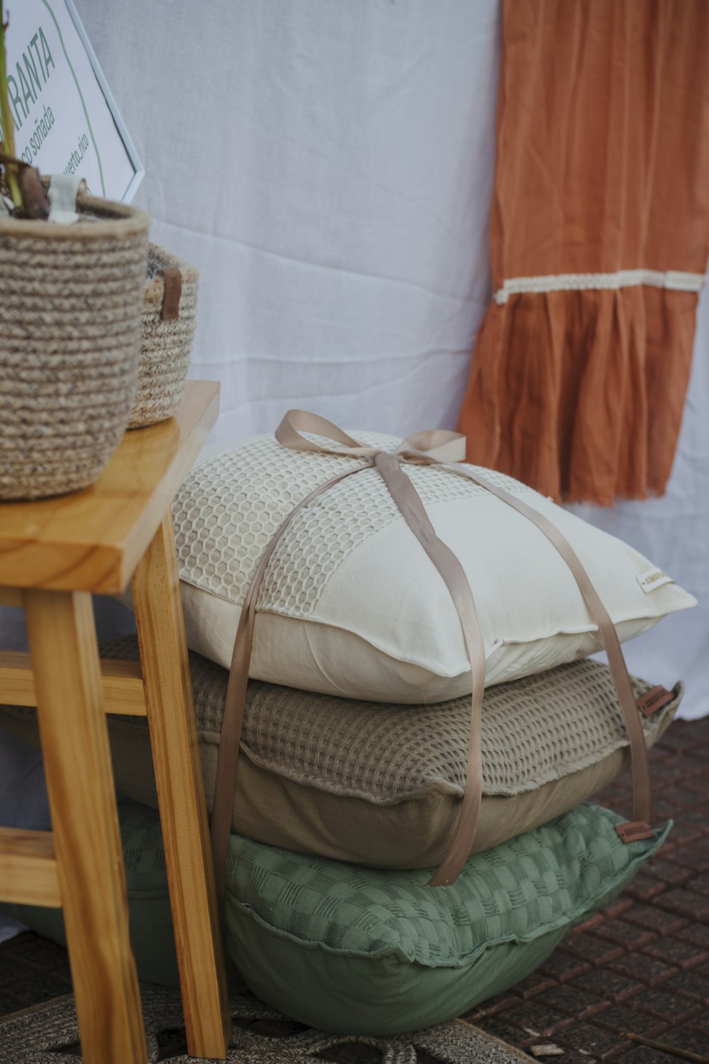 a pile of pillows sitting on top of a wooden table