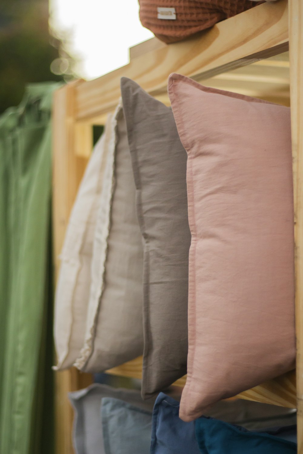 a row of pillows sitting on top of a wooden shelf